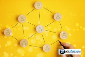 Blue back ground image with a hand with a pen connecting lines between wooden circles representing people on a yellow background.