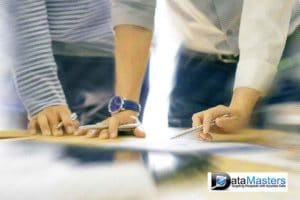 Image of two people standing side by side looking down at a document