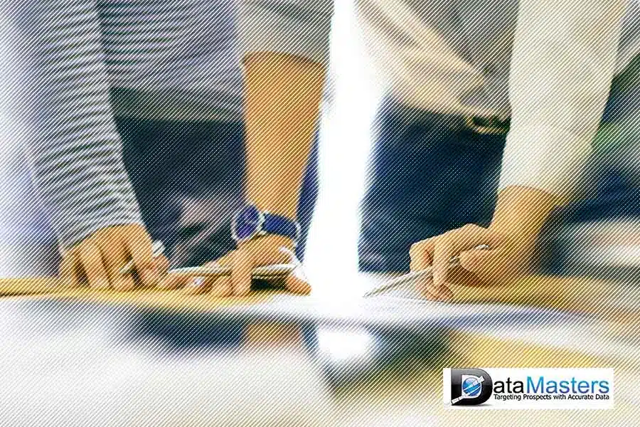 Busines mailing lists page by Datamasters Image of two people standing side by side looking down at a document