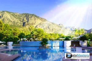 Blue back ground image with image on the right showing a swimming pool against a background of a mountian and blue skies.